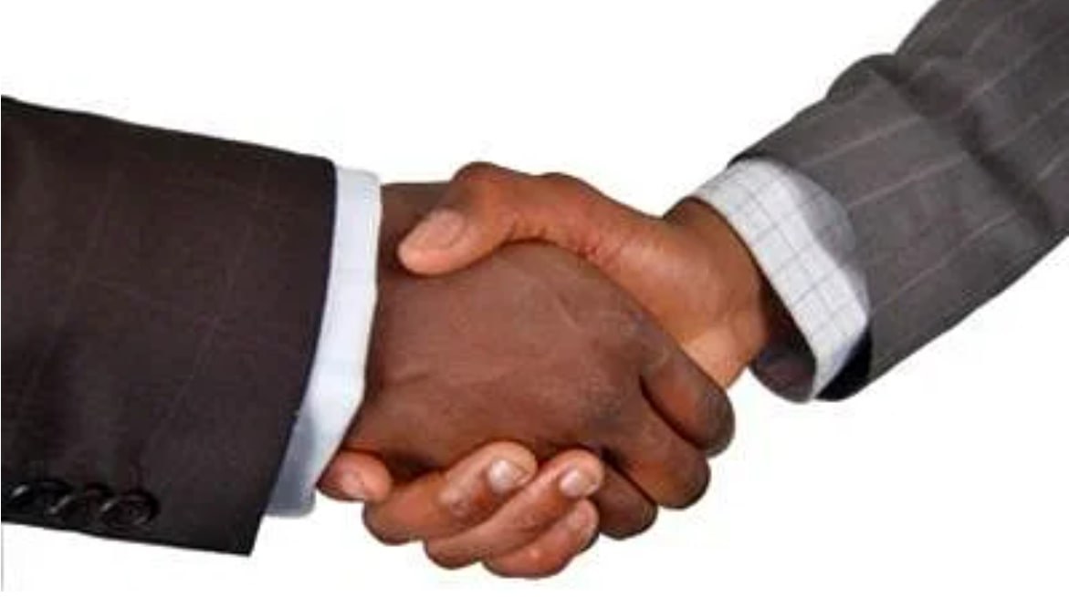 Two business people in suits shaking hands